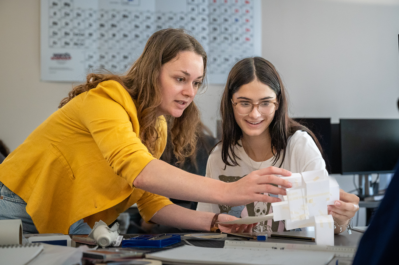 A professor assists an architecture student on a tactile design project.