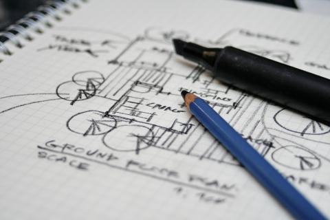Sketch of a ground floor plan on graph paper with a pencil and marker.