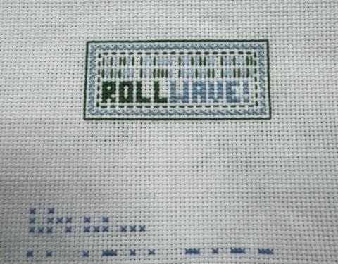 Embroidery with "ROLLWAVE!" and decorative border created by a pre-college student.