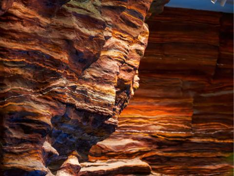 Canyon wall with vivid orange and brown layered rock formations.