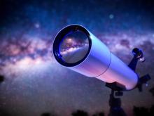 Telescope focused on the Milky Way galaxy with a starry night sky.