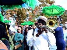 Man in white shirt playing a trombone in a secondline to close out Tulane commencement ceremony.
